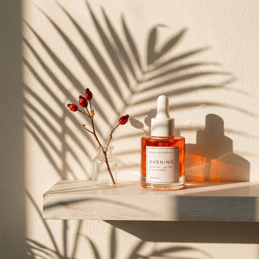 Evening face oil golden-hour shelfie with rosehip branch
