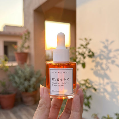 Raw Alchemy Evening face oil glowing against the sunset